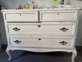 Cómoda antigua blanca con detalles dorados.
