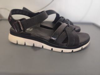 Sandalias negras de tiras con suela blanca.