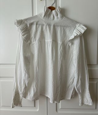 Blusa blanca de algodón con fruncidos y volantes