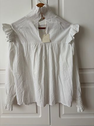Blusa blanca de algodón con fruncidos y volantes