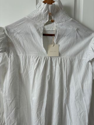 Blusa blanca de algodón con fruncidos y volantes