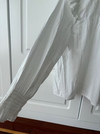 Blusa blanca de algodón con fruncidos y volantes