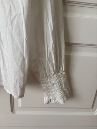Blusa blanca de algodón con fruncidos y volantes