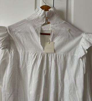 Blusa blanca de algodón con fruncidos y volantes
