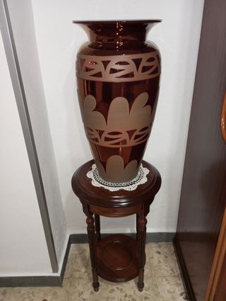 Jarrón de cerámica y mueble de madera con tapete