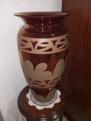 Jarrón de cerámica y mueble de madera con tapete