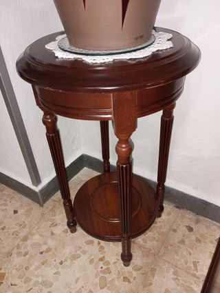 Jarrón de cerámica y mueble de madera con tapete