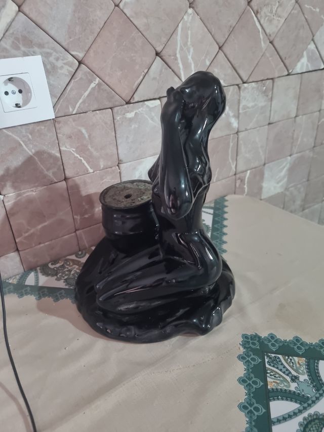 Figura de cerámica negra con maceta