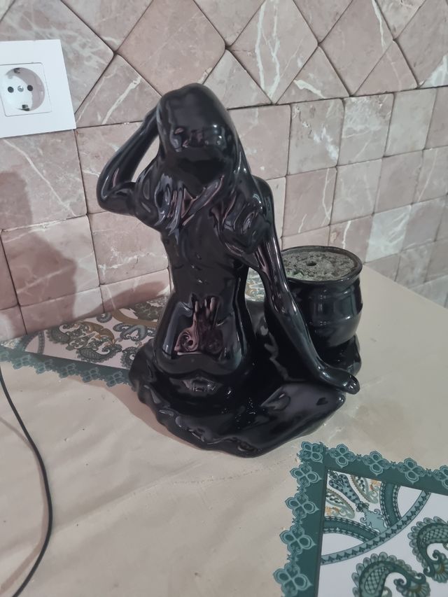 Figura de cerámica negra con maceta
