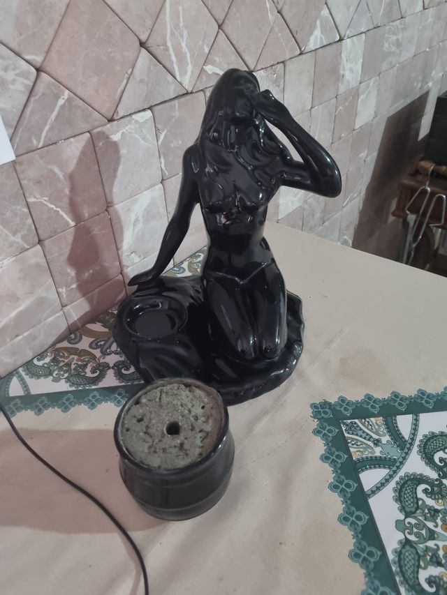 Figura de cerámica negra con maceta