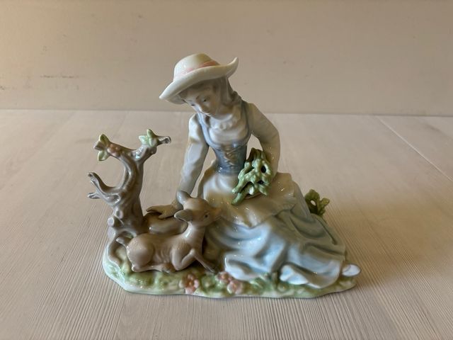 Figura de porcelana de niña y ciervo