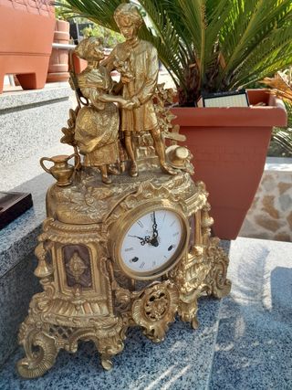 Reloj de sobremesa dorado con figuras
