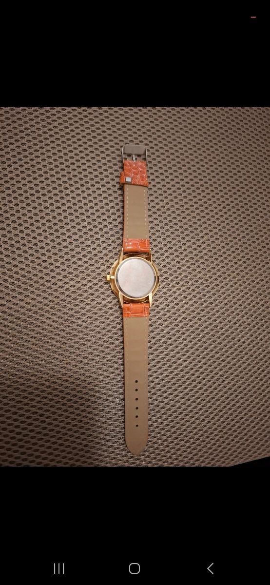 Reloj dorado con correa naranja