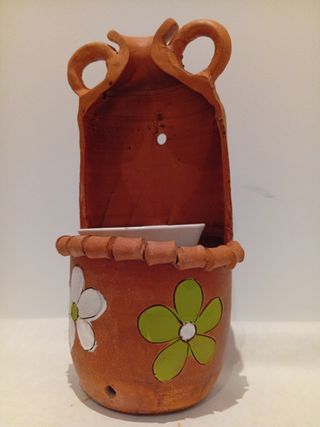 Maceta colgante de terracota con flores