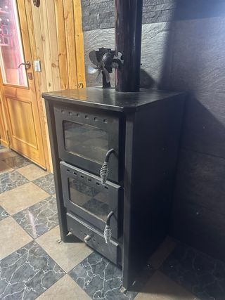 Estufa de leña negra con horno.
