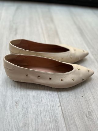Zapatos planos beige con tachuelas doradas