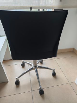 Silla de oficina negra con base plateada.