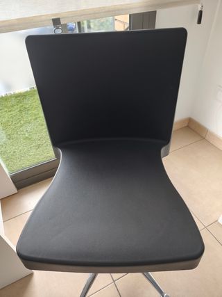 Silla de oficina negra con base plateada.