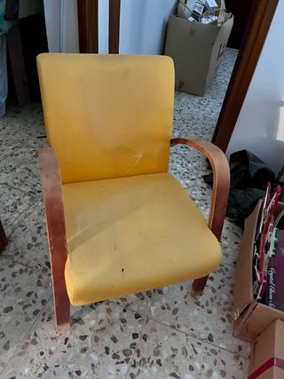 Sillón tapizado amarillo con estructura de madera