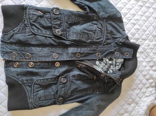 Chaqueta negra con cremallera y bolsillos.