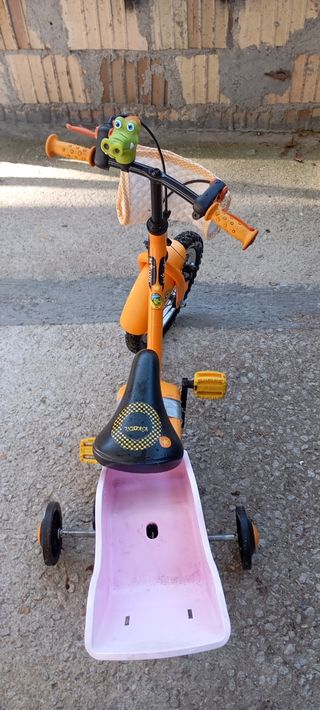 Bicicleta infantil naranja con ruedines