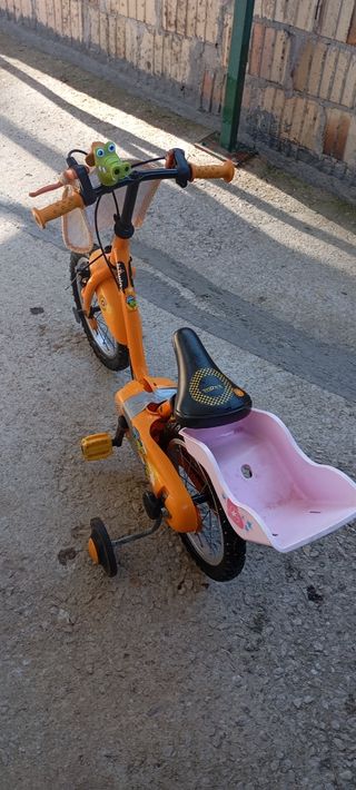 Bicicleta infantil naranja con ruedines