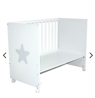 Cuna de bebé blanca con tres estrellas y colchón.