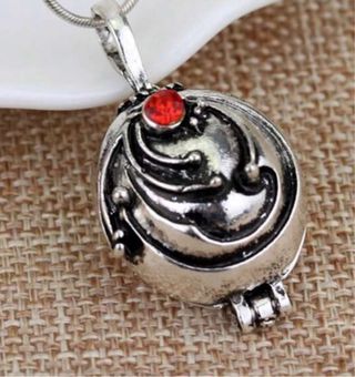 Collar con piedra roja y detalles plateados