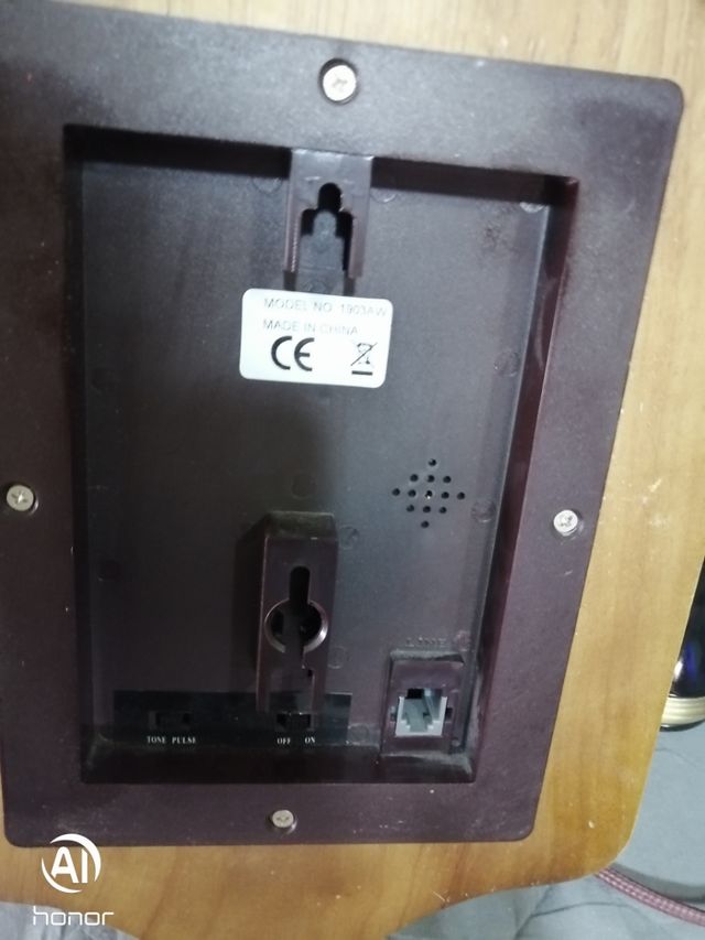 Telefono antico in legno con parete dorata