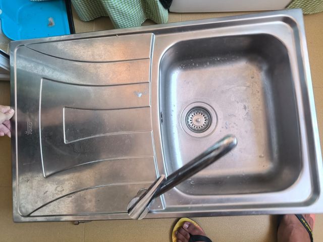 Fregadero y grifo de metal plateado