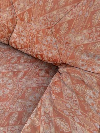 Sofá cama tela anaranjada con estampado 