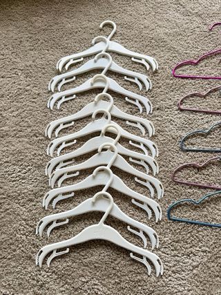 Lote 23 perchas infantiles de plástico y metal