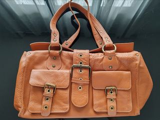 Bolso de piel marrón con hebillas metálicas.