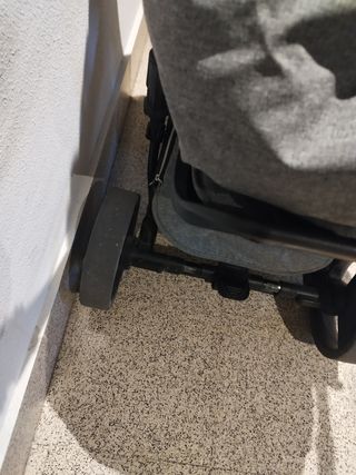 Silla de paseo gris..ruedas con signos de desgaste