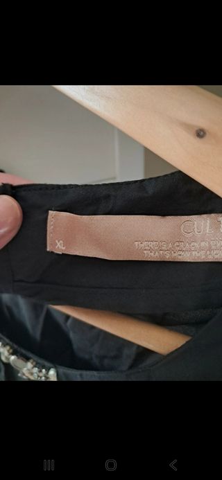 Camisa negra con pedrería. Falta alguna piedra