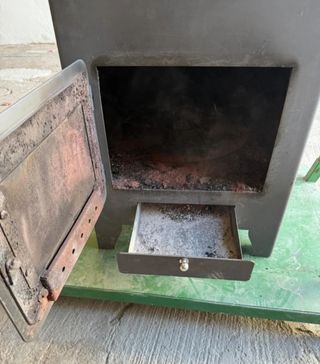 Estufa de leña metálica con puerta de cristal