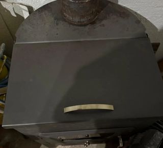 Estufa de leña metálica con puerta de cristal