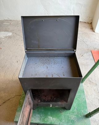 Estufa de leña metálica con puerta de cristal