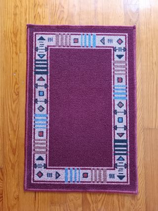 Alfombra pie de cama con diseño geométrico.