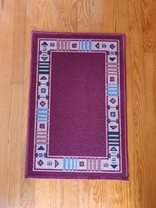 Alfombra pie de cama con diseño geométrico.