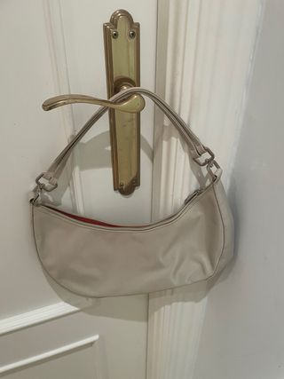 Bolso de mano beige con interior rojo