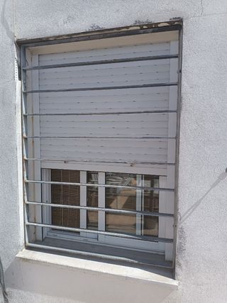 Ventana con reja y persiana