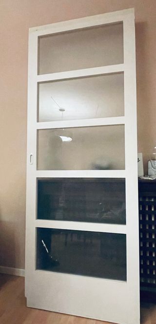 Puerta corredera blanca con cristales traslúcidos 