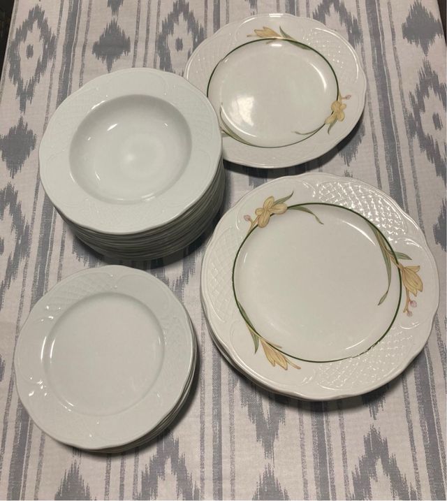 Vajilla cerámica blanca con hojas verdes .