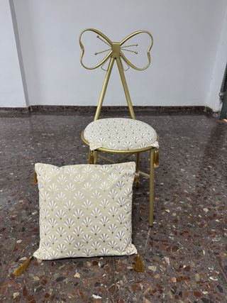 Silla dorada con cojín decorativo