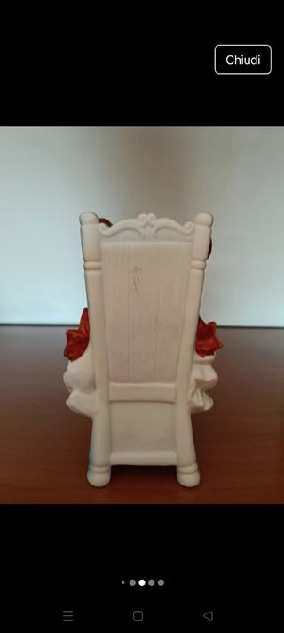 Bambola Capodimonte seduta su sedia