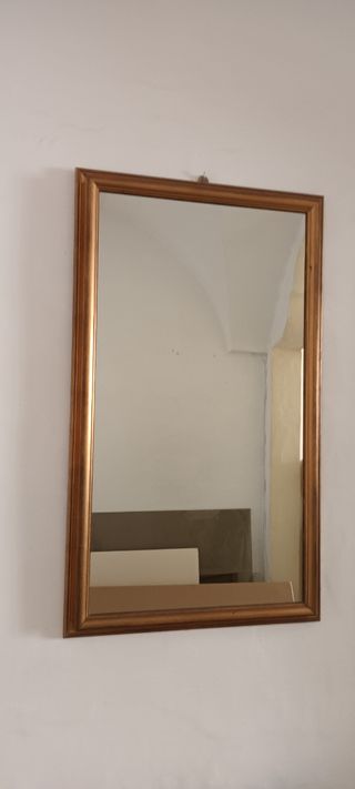 Specchio con cornice in legno dorato.
