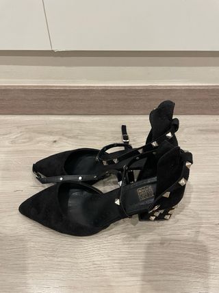 Zapatos de tacón beige y negros con diamantes.