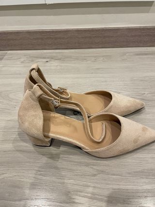 Zapatos de tacón beige y negros con diamantes.