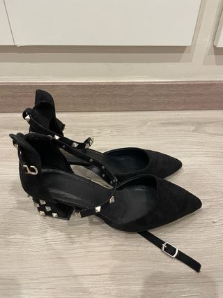 Zapatos de tacón beige y negros con diamantes.